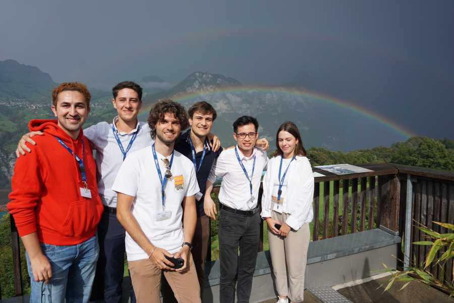 Group of students in front of a rainbow